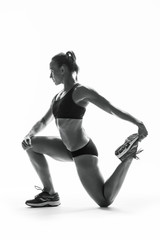 Athletic young woman doing stretching fitness exercise, isolated. Intense stretch pose