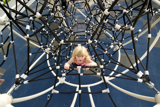 Young girl climbing on playground equipment; Lethbridge, Alberta, Canada