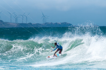 Amazing kite surfing at Philippines. Processional instructor surfing in ocean waives near windmills