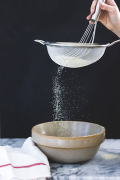 Sieving flower in to a mixing bowl.