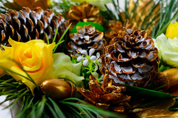 Christmas decoration with golden fir cones and silk roses