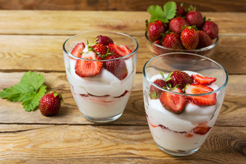 Summer layered cream cheese dessert and strawberry in glass bowl