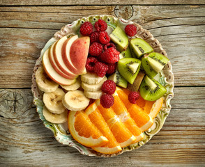 plate of fruit pieces and raspberries
