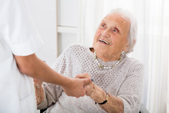 Senior Patient Holding Hands Of Female Doctor