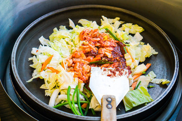 One of Korean favorite : Korean spicy stir fried vegetable, chicken and Korean spicy sauce (Gochujang) in big hot pan know as Dak Galbi