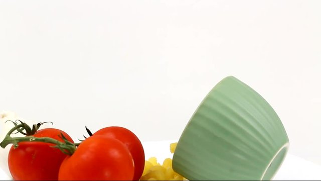 Rotating Cavatappi pasta in a bowl with tomatoes and garlic