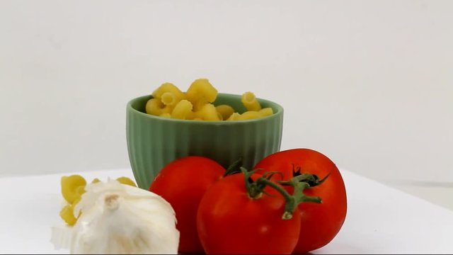 Rotating Cavatappi pasta in a bowl with tomatoes and garlic