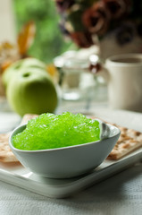 apple jam and crackers, coffee cup on the table, light from the window