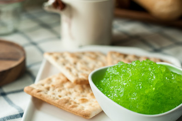 apple jam and crackers, coffee cup on the table, light from the window