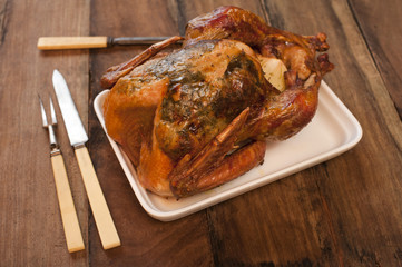 Roast chicken on a rectangular plate with carvers