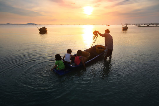 Silhouette scenery of the livelihoods of fishermen during time the sunset and the beautiful natural of the colorful sky at Bang Phra beach , Chonburi province in Thailand.