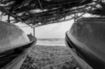 Fototapeta blurred image of fisherman boat under wooden  cottage. fronds ro obraz