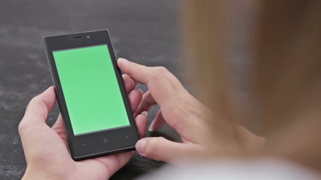 Woman using smartphone with green screen. Close up shot of woman's hands with mobile. Various hand gestures - scrolling and touching