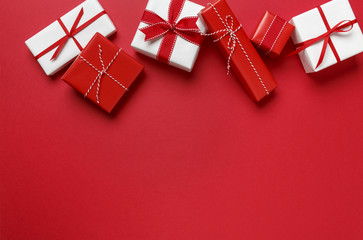Christmas gifts presents on red background. Simple, classic red and white wrapped gift boxes with ribbon bows horizontal top border.