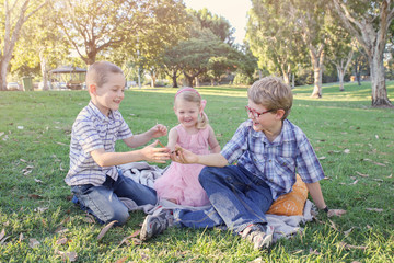 Fototapeta premium Happy brothers and sister playing at the park