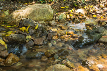 Fototapeta na wymiar Background Picture of water flows through rocky path of a stream
