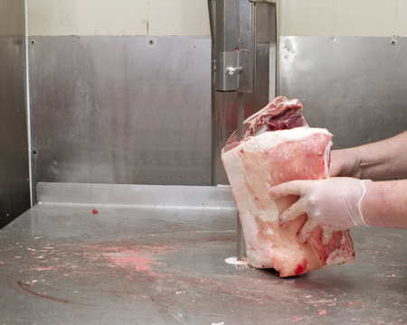 Butcher cutting meat with a Band saw - Powered by Adobe
