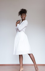 Naklejka premium Afro american woman holding vintage camera and taking photograph