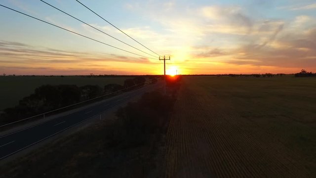 Aerial view of outback highway or open road on dusk (sunset) with truck traveling on rural country high speed freeway or motorway driving scenes on open road. 
