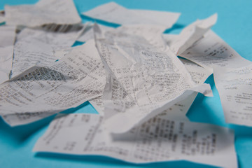 Pile of shopping receipts on blue background