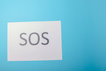 Word SOS written on paper