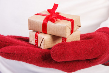 Hand of woman in gloves with gifts for Christmas or other celebration