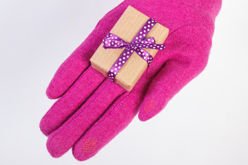 Hand of woman in gloves with gift for Christmas or other celebration