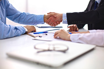 Business meeting at the table shaking hands conclusion of the contract