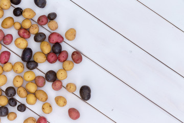 Scattered fresh multicolored baby potatoes