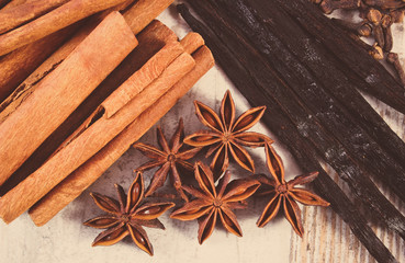 Vintage photo, Cinnamon sticks, vanilla, star anise and cloves on wooden surface