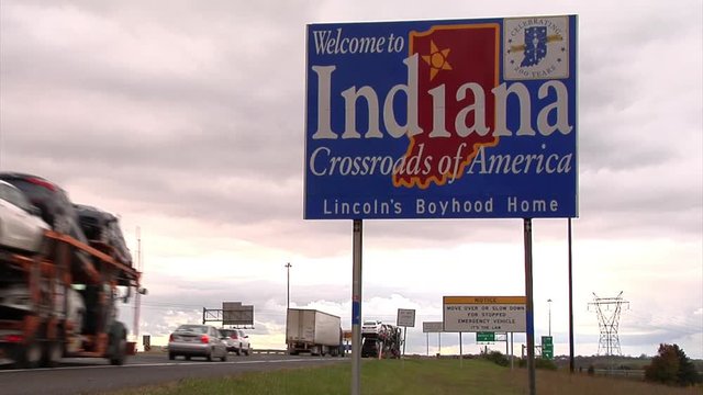 Welcome to Indiana" sign, highway traffic in background."elcome to Indiana" sign, highway traf"lcome to Indiana" s"co