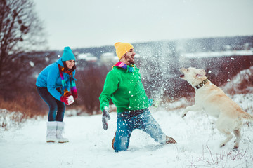  amazing young couple playing with big dog in winter
