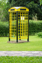 Yellow phone booth on green grass
