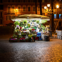 bright illuminated flower stand at night in the streets of Rome, Italy, Europe