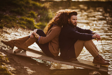 Bearded man and stylish woman sit back to back on the door over