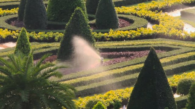 Automatic lawn watering device. Ornamental garden with landscape design. Nong Nooch Tropical Garden in Pattaya, Thailand.