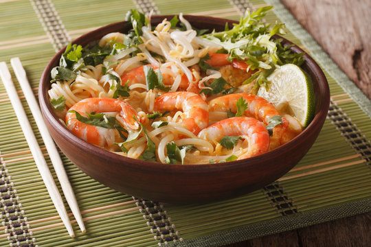 Laksa soup with shrimps, noodles, sprouts and coriander in a bowl close-up. Horizontal