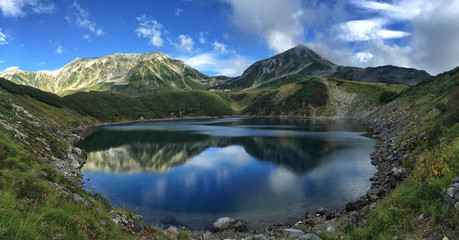 Panorama shot of Mount Tateyama mirrored in the Mikurigaike pond's cobalt blue surface at Murodo,...