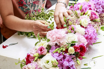 Woman making floral arrangement with carnation, eustoma and hort