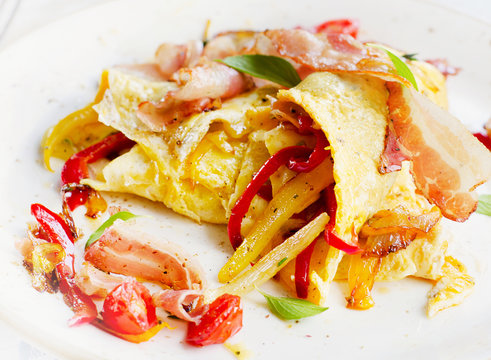 Omelet with bacon and vegetables for healthy breakfast .