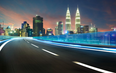 Fototapeta na wymiar Blue neon light highway overpass motion blur with city skyline background , night scene .