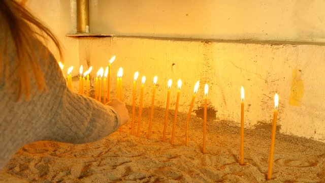 Lighting Votive candles in an old church