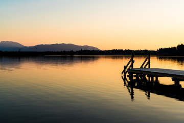 Fototapeta premium Kirchsee nahe Bad Tölz mit vom Sonnenuntergang erleuchtetem Wasser
