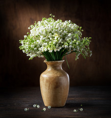 Obraz premium Lily of the valley bouquet on the wooden table.