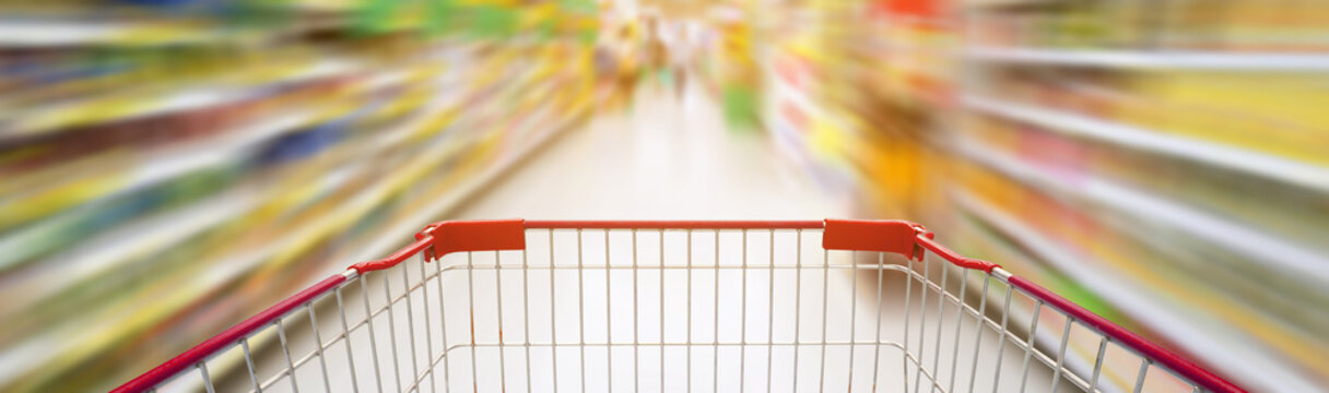 supermarket aisle with empty red shopping cart