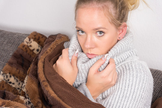 Frau krank aud der Couch mit Decke5