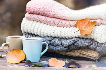 Obraz na płótnie Canvas Knitted clothes coffee mugs on wood. Fall season mood icon.