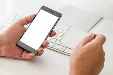 Mobil payment or digital banking concept. Hand holding smart phone and blank card,  on the working desk.