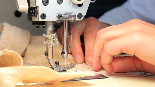 Seamstress at work by the sewing-machine