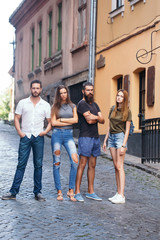 Four friends standing on street